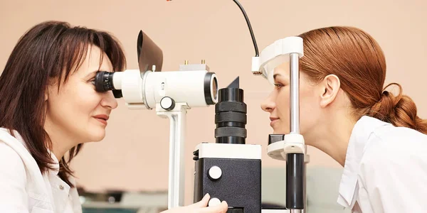 Ophthalmologist doctor in exam optician laboratory with female patient. Eye care medical diagnostic. Eyelid treatment — Stock Photo, Image