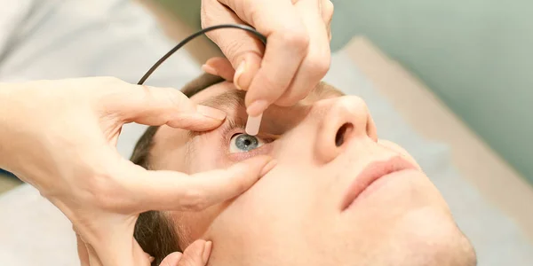 Oftalmologista médico em laboratório de óptica exame com paciente do sexo masculino. Homens olho cuidados diagnóstico médico. Tratamento da pálpebra — Fotografia de Stock