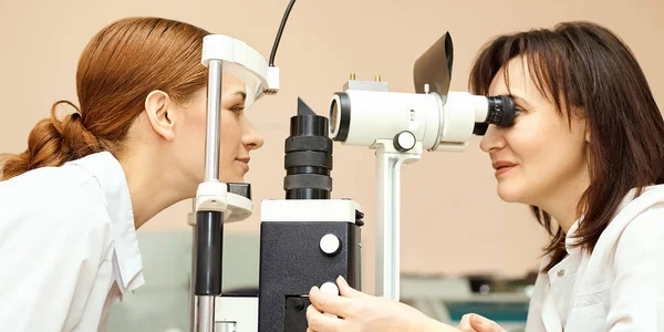 Oftalmólogo médico en laboratorio óptico examen con paciente femenino. Diagnóstico médico del cuidado ocular. Tratamiento de párpados Imagen de stock