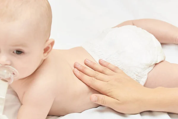 Pasgeboren jongen, moederhand. Babymoeder massage. Grappige kinderen verschonen luier. Thuis servet — Stockfoto