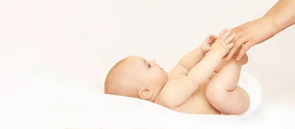 Pasgeboren jongen, moederhand. Babymoeder massage. Grappige kinderen verschonen luier. Thuis servet — Stockfoto