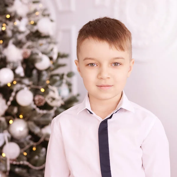 Christmas happy boy. Luxury attractive red hair child. Xmas miracle. Green tree, lights, bokeh, new year interior — 스톡 사진