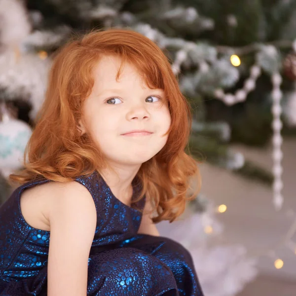 Święta szczęśliwa dziewczyna. Luksusowe, atrakcyjne, rude włosy dziecko. Świąteczny cud. Zielone drzewo, światła, bokeh — Zdjęcie stockowe