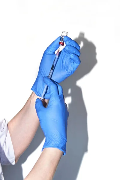 Kesztyűben lévő személy tartsa a vakcinásüveget fecskendővel — Stock Fotó