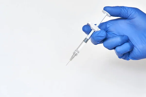 Человек в перчатках держит шприц с вакциной — стоковое фото