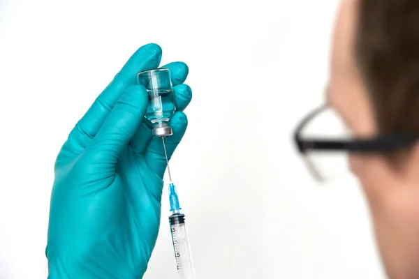 Persoana din mănuşi ţine flaconul de vaccin cu seringă — Fotografie, imagine de stoc