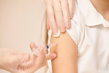 Doktor genç kıza iğne yapacak. Çocuk aşılama