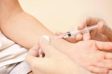 Doktor genç kıza iğne yapacak. Çocuk aşılama