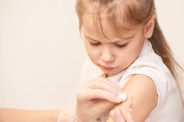 Doktor genç kıza iğne yapacak. Çocuk aşılama