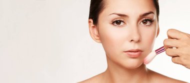 Makyaj sanatçısı güzel genç bayana rimel yapıyor.