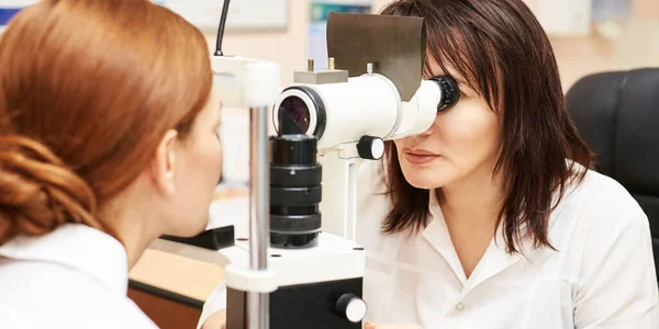 Ophthalmologist doctor in exam optician laboratory with female patient. Eye care — Stock Photo, Image