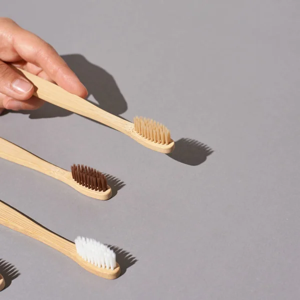 Hand hold bamboo eco tooth brush. Grey background — Stock Photo, Image