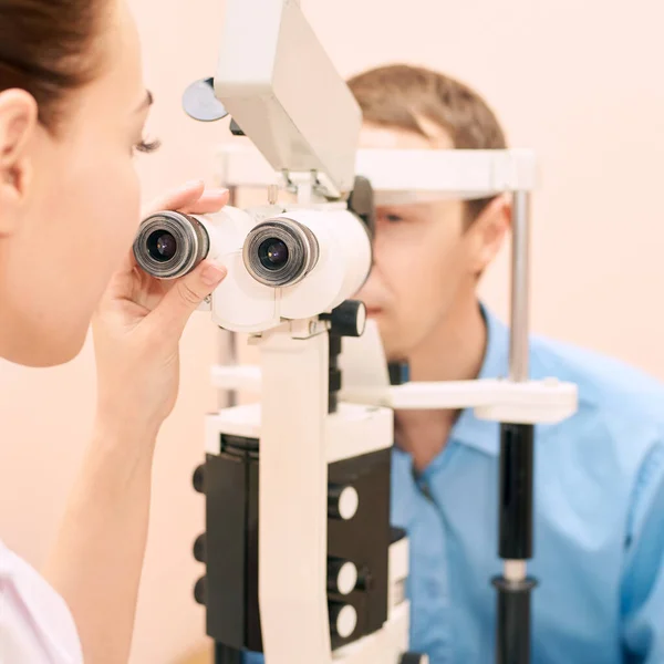 Szemész orvos a vizsgálat optikus laboratóriumban férfi beteggel. Férfi szem — Stock Fotó