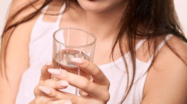 Kız bardakta saf su içiyor. Temiz mineral susuzluğu. Kahvaltı diyeti.