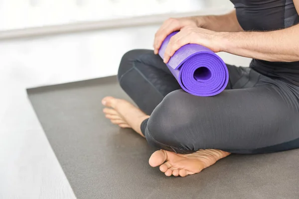 Person holding yoga mat at knee. Sport equipment concept — Stock Photo, Image