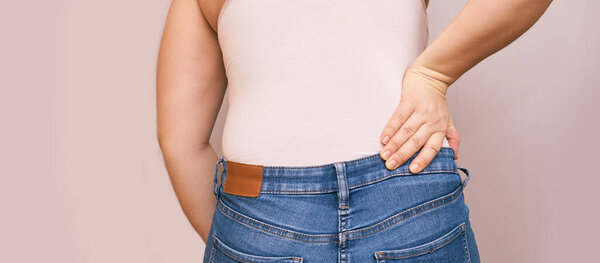 Женщина внизу спины болит. Держитесь за руку рядом с телом
