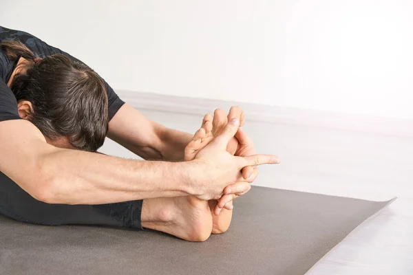 stock image Yoga man at paschimottanasana. Class for exercise or fitness strength