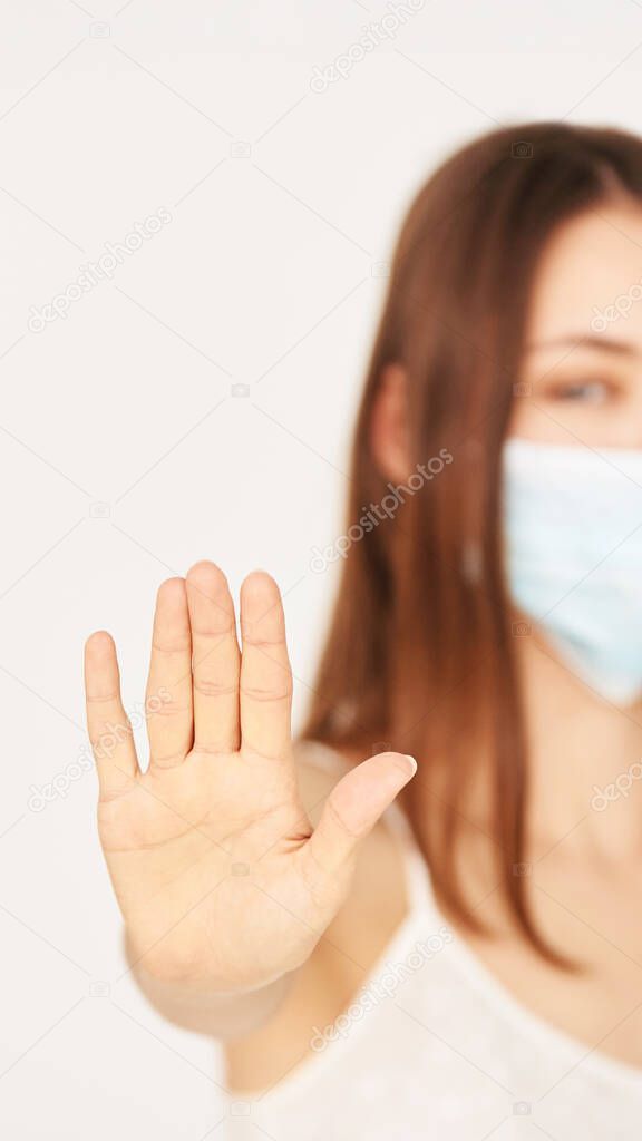 Influenza virus stop gesture. Girl in face mask show deny sign. selective focus.