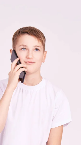 Un joven hablando por teléfono. Camisa blanca sobre fondo gris. Hombres — Foto de Stock