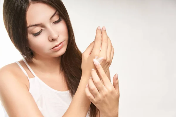 Hermosa chica joven con crema de manos. Loción hidratante para la piel. Producto protector solar — Foto de Stock