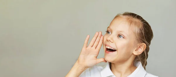 En liten kvinna ler porträtt. Sido skriker med handen nära huvudet. Kvinnliga barn — Stockfoto