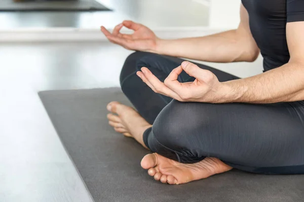 Yoga calm pose. Lotus asana at studio training. Man seated at mat