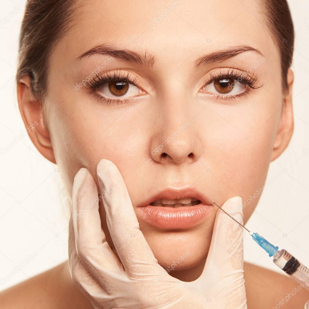 Face female injection. Doctor hand near beauty portrait. Salon toxin procedure.