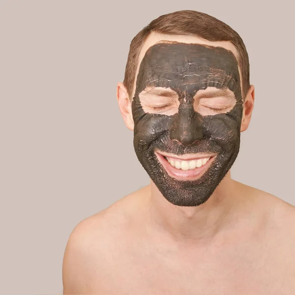 Czarna maska gliny na twarzy faceta — Zdjęcie stockowe