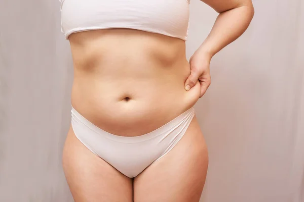 Жирное нездоровое тело женщины. Щепотка живота. Измерение — стоковое фото