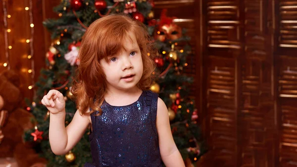 Счастливая девушка на Рождество. Роскошные привлекательные рыжие волосы ребенка. Рождественское чудо . — стоковое фото