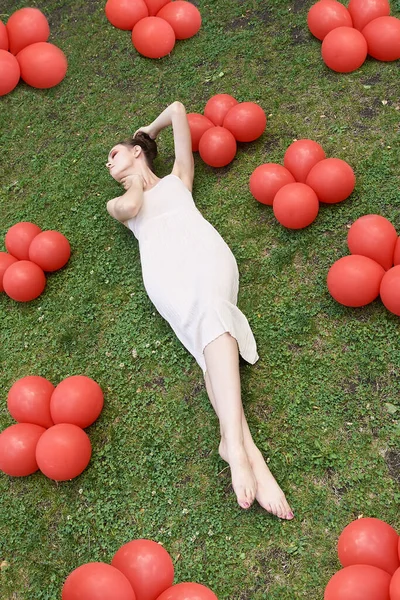 Pretty young woman lying down on grass. Fashion model — Stock Photo, Image