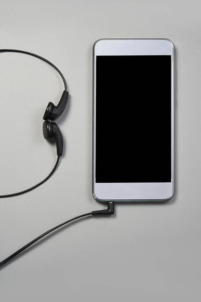Podcast concept. Phone and earphones. Grey background — Stock Photo, Image