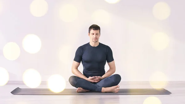 Man sitting at lotus yoga pose. Home morning routine.