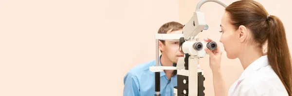 Oftalmólogo médico en laboratorio óptico examen con paciente masculino. — Foto de Stock