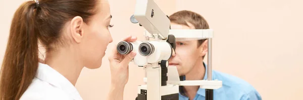 Oftalmologista médico em exame laboratório óptico com paciente do sexo masculino. — Fotografia de Stock