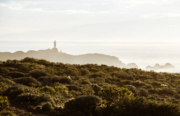 Faro sobre rocas en niebla — Foto de Stock