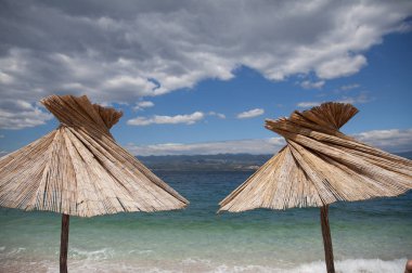 deniz manzarası ve iki plaj şemsiyeleri