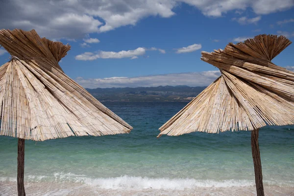 Paisagem marinha e dois guarda-chuvas de praia Imagens De Bancos De Imagens