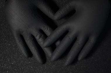 Siyah arka planda tek kullanımlık güzel tıbbi eldivenler. Kavram: eldivenli eller karanlıktan çıkar. Metin için boşluk var.