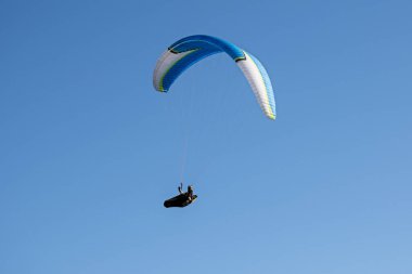Mavi gökyüzünde uçan bir paraglider. İtalyan Alpleri. Piedmont 'ta. İtalya