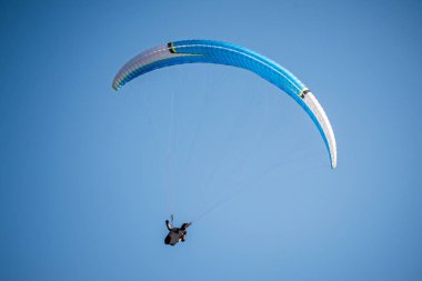 Mavi gökyüzünde uçan bir paraglider. İtalyan Alpleri. Piedmont 'ta. İtalya
