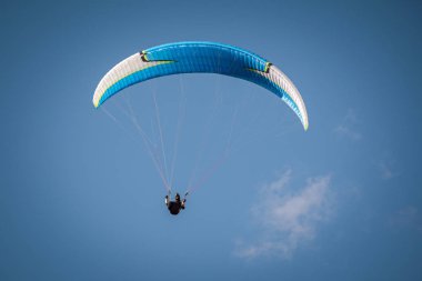 Mavi gökyüzünde uçan bir paraglider. İtalyan Alpleri. Piedmont 'ta. İtalya