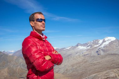 Dağ kışı kıyafetleri giymiş bir adam manzaraya bakıyor. İtalyan Alpleri