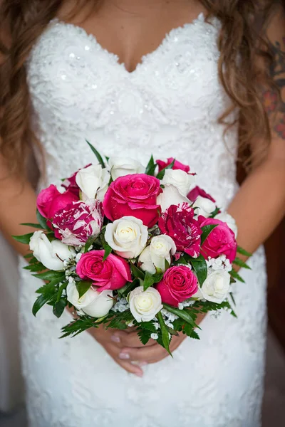 wedding roses bouquet in bride\'s hands, close up.