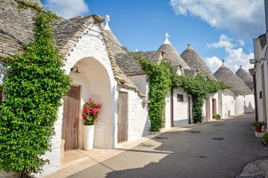 Alberobello, Puglia, İtalya 'dan Trulli: Kuru taş duvarları ve konik çatıları olan tipik evler. Güzel güneşli bir günde.