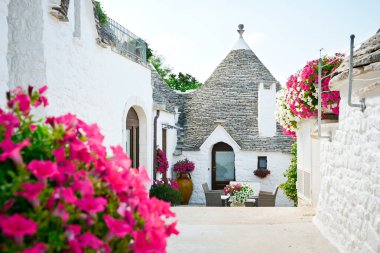 Alberobello, Puglia, İtalya 'dan Trulli: Kuru taş duvarları ve konik çatıları olan tipik evler. Güzel güneşli bir günde.