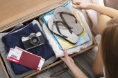 Draufsicht auf junge Frau mit Reisetasche, Reisekonzept