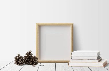 çam kozalakları ahşap zemin üzerinde ve kitaplar ile boş fotoğraf çerçevesi 