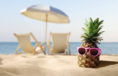 kumlu plaj tatil kavramı üzerinde güneş gözlüklü olgun tropikal ananas 
