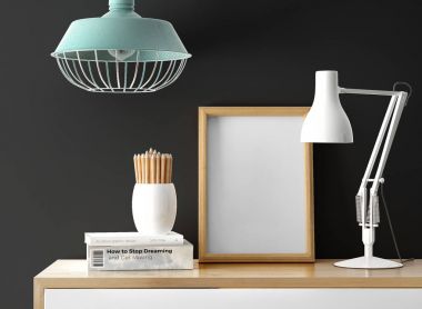 boş fotoğraf çerçevesi ile masa lambası ve yığın tablo kalemleri ile kitap 